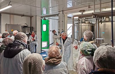 Personnes qui discutent dans un atelier de traitement de lait