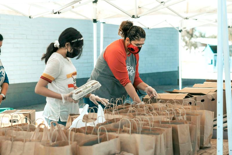 Deux personnes en train de préparer une distribution alimentaire