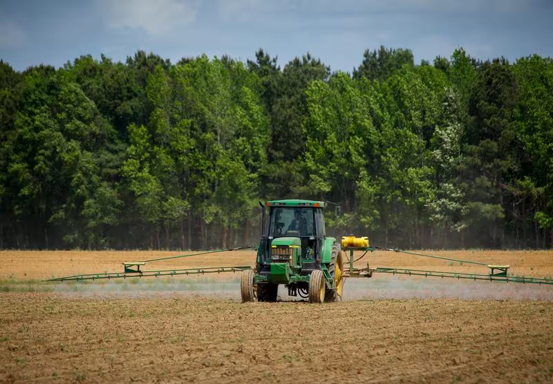 Tracteur épandant des pesticides